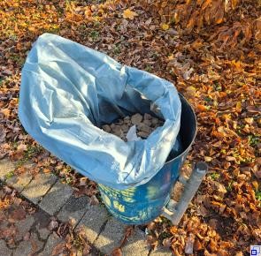 Blick von oben in einen Mülleimer, der mit Schutt gefüllt ist.